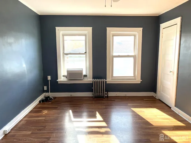 a view of a room with wooden floor and a window