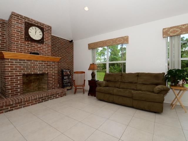 12557 154th Road North Jupiter, FL 33478 - Photo 8 of 38 a living room with furniture a fireplace and a large window