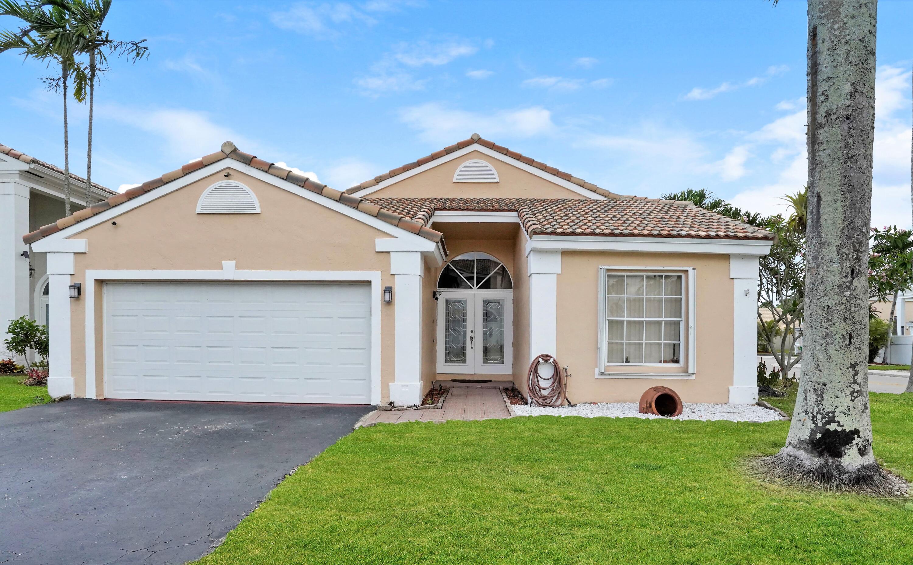 14001 Oak Ridge Drive Davie, FL 33325 - Photo 1 of 41 a front view of a house with a garden and plants