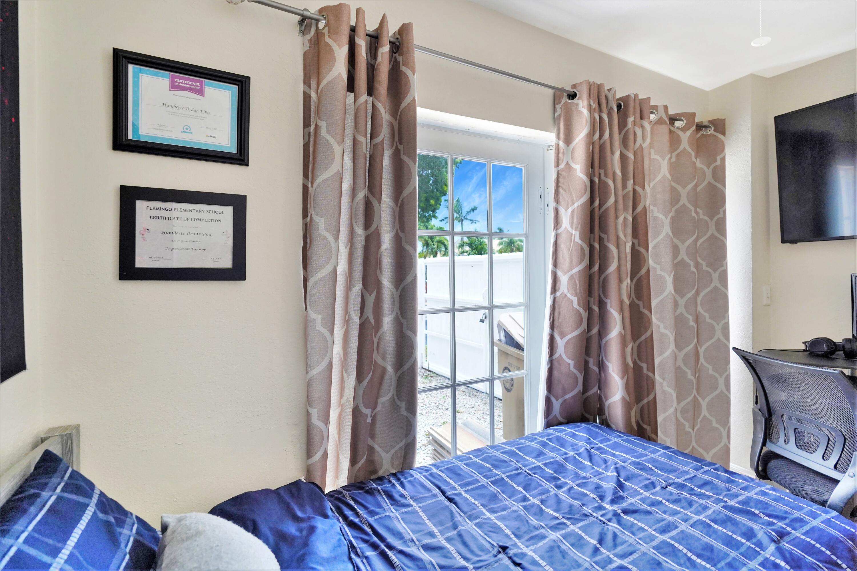 14001 Oak Ridge Drive Davie, FL 33325 - Photo 18 of 41 a bedroom with a bed and a window