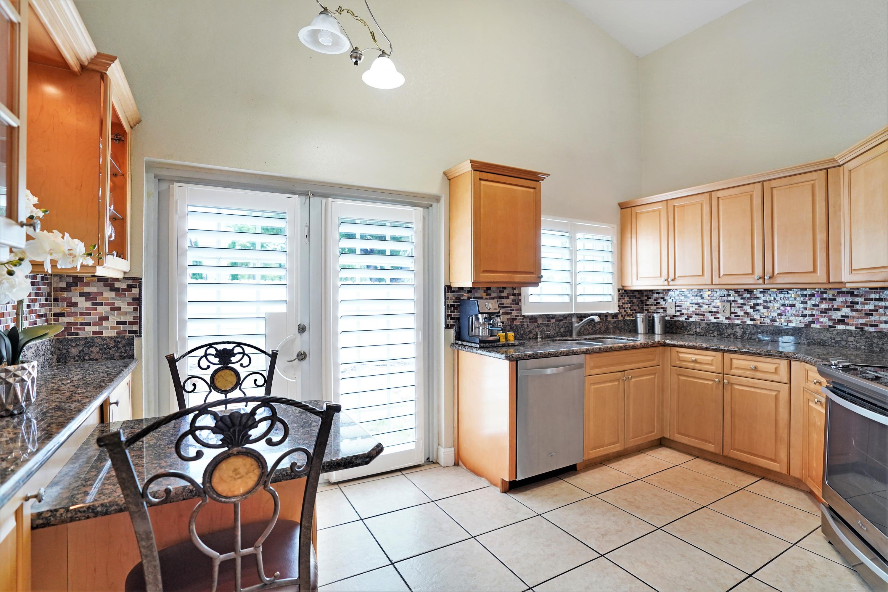 14001 Oak Ridge Drive Davie, FL 33325 - Photo 19 of 41 a kitchen with stainless steel appliances granite countertop a stove and more cabinets