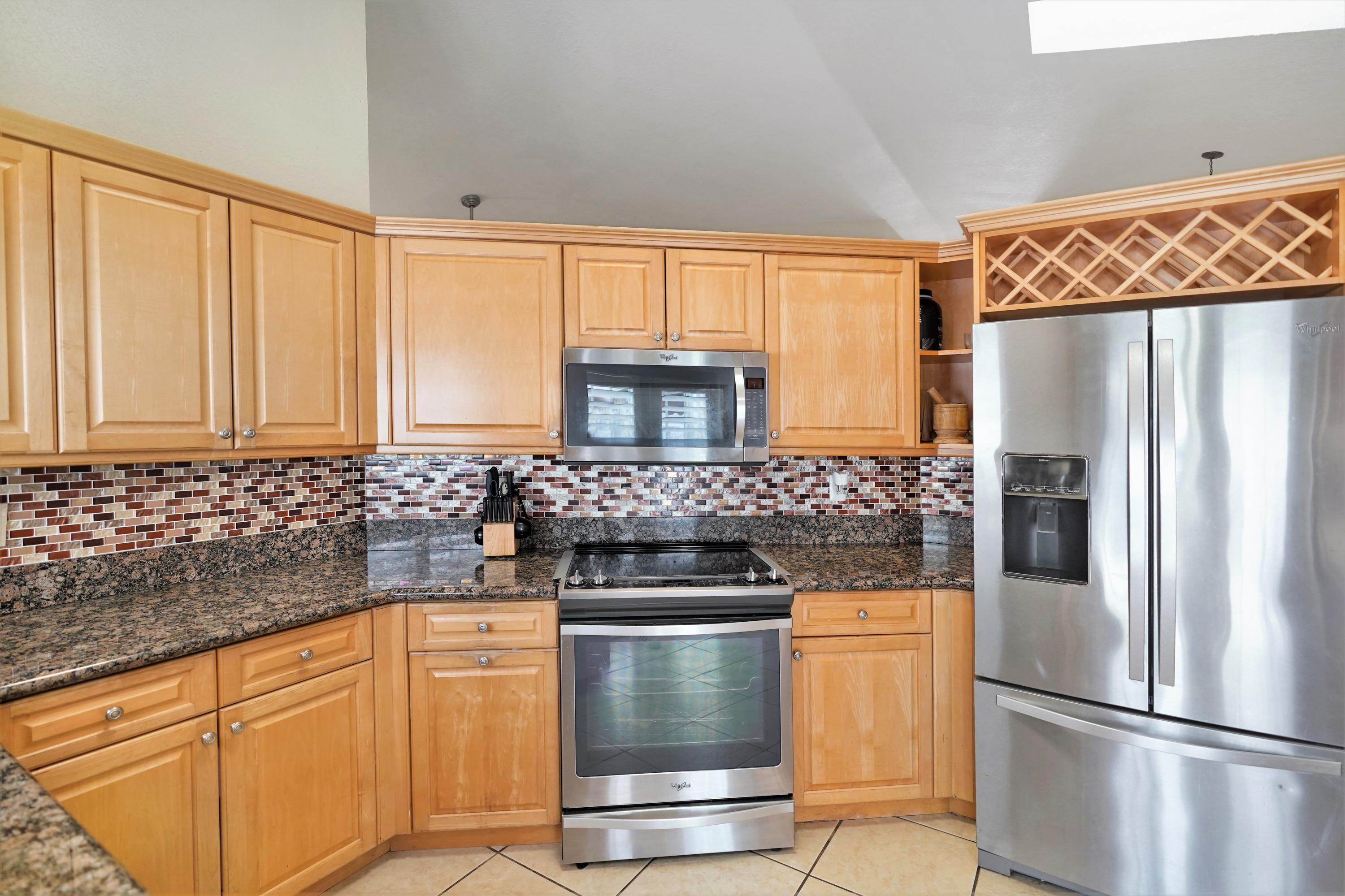 14001 Oak Ridge Drive Davie, FL 33325 - Photo 21 of 41 a kitchen with granite countertop white cabinets and stainless steel appliances