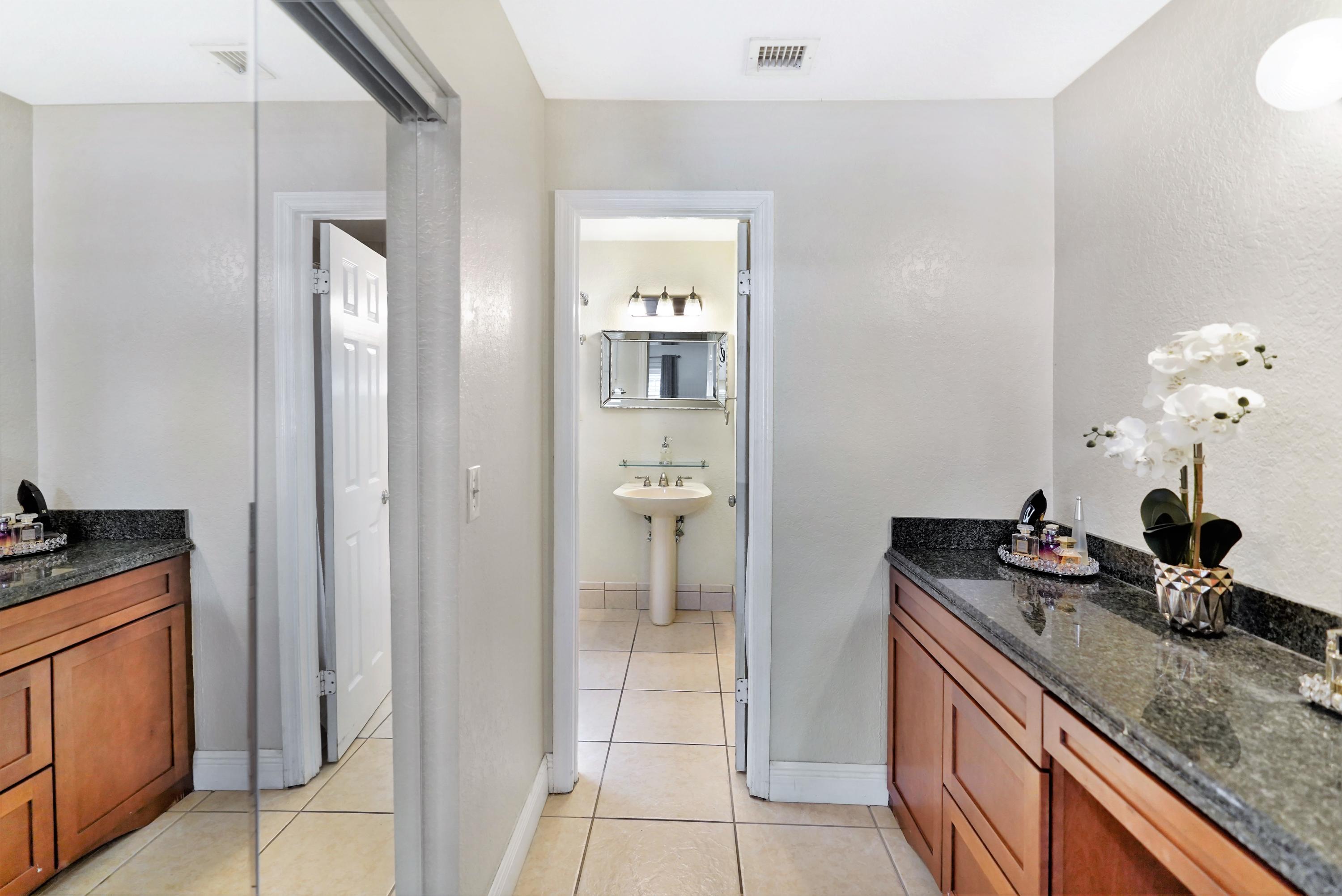 14001 Oak Ridge Drive Davie, FL 33325 - Photo 27 of 41 a bathroom with a granite countertop sink and a mirror