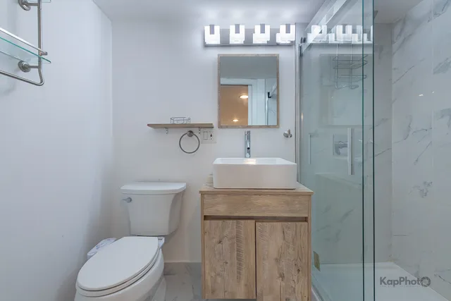 a bathroom with a toilet sink and mirror