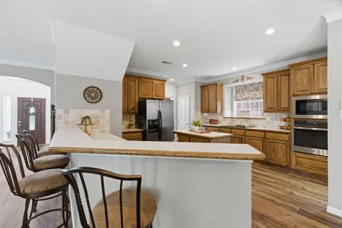 a large kitchen with granite countertop lots of counter space and windows