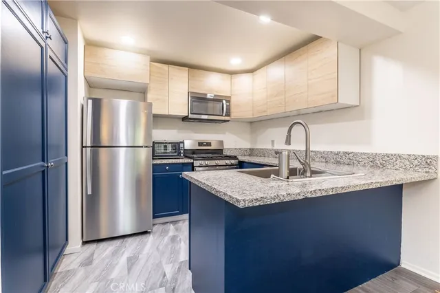 a kitchen with stainless steel appliances granite countertop a refrigerator sink and cabinets