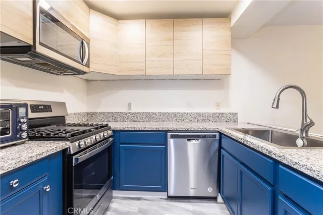 a kitchen with stainless steel appliances granite countertop a sink stove and cabinets