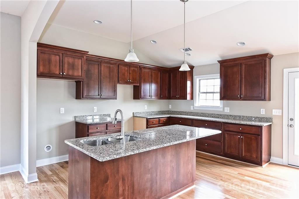 3324 Sincerity Road, Unit 6 Monroe, NC 28110 - Photo 11 of 29 a kitchen with stainless steel appliances granite countertop a sink stove a refrigerator and a oven with wooden floor