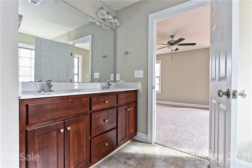 3324 Sincerity Road, Unit 6 Monroe, NC 28110 - Photo 21 of 29 a bathroom with a double vanity sink a mirror and a shower