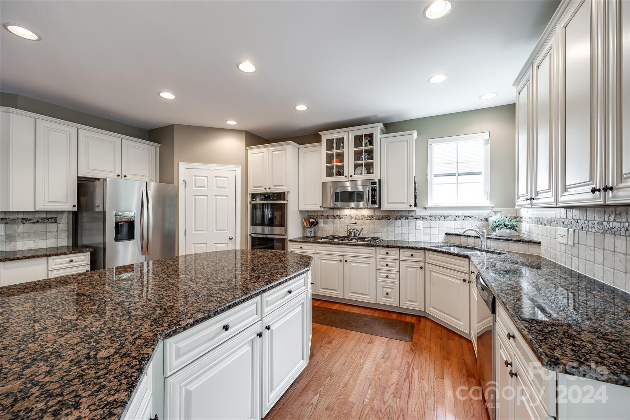 352 Calming Way Tega Cay, SC 29708 - Photo 16 of 48 a large kitchen with granite countertop a large counter top sink stainless steel appliances and cabinets
