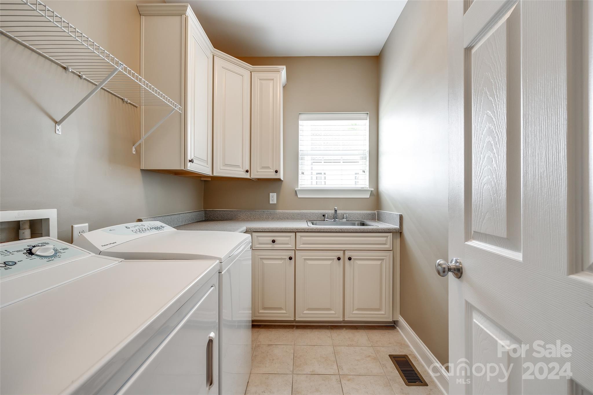 352 Calming Way Tega Cay, SC 29708 - Photo 20 of 48 a utility room with stainless steel appliances white cabinets and a window