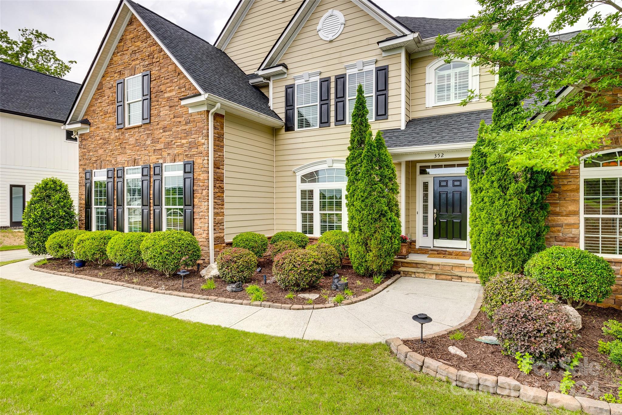 352 Calming Way Tega Cay, SC 29708 - Photo 2 of 48 a view of a house with a yard and plants