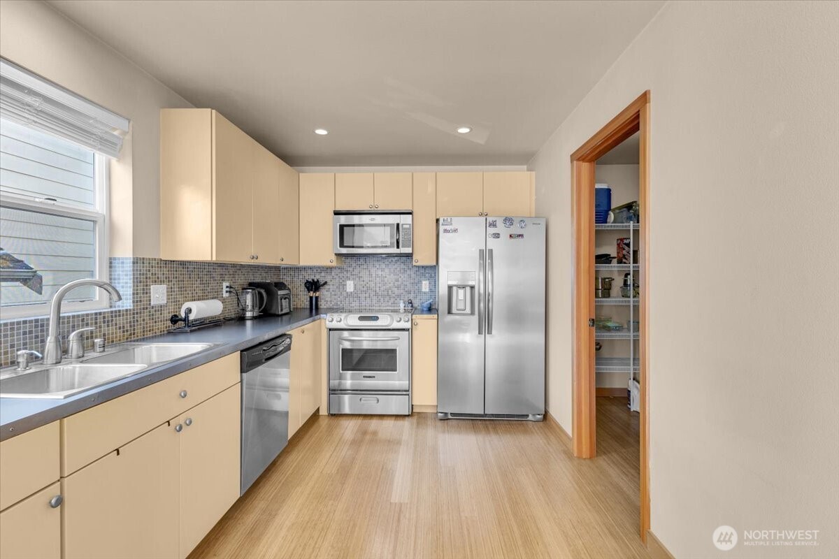 1719 Southwest Henderson Street Seattle, WA 98106 - Photo 4 of 22 a kitchen with a refrigerator a sink and cabinets
