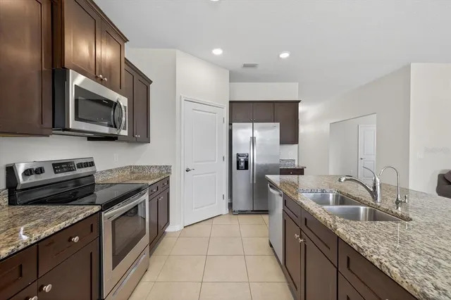 a kitchen with granite countertop stainless steel appliances a stove sink and microwave