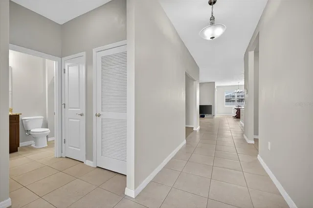 a view of a hallway with wooden floor and a bathroom