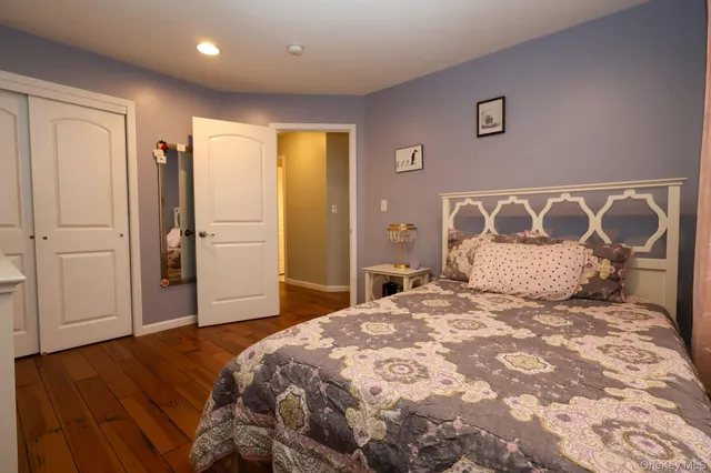 a bedroom with a large bed and wooden floor