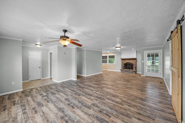 a view of empty room with wooden floor and window