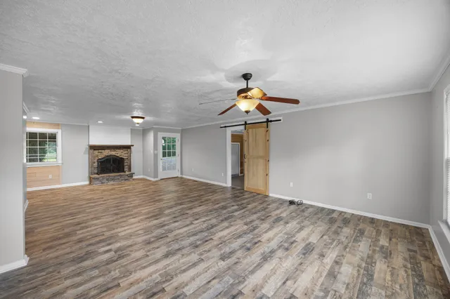 a view of empty room with wooden floor and fireplace