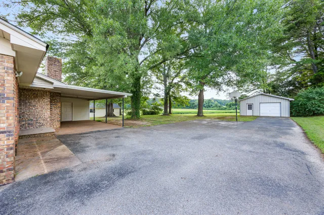 a view of a house with large outdoor space and a forest