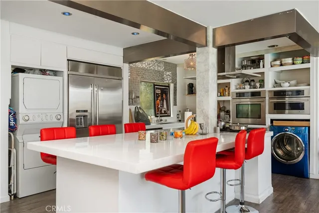 a hall with kitchen island stainless steel appliances and furniture
