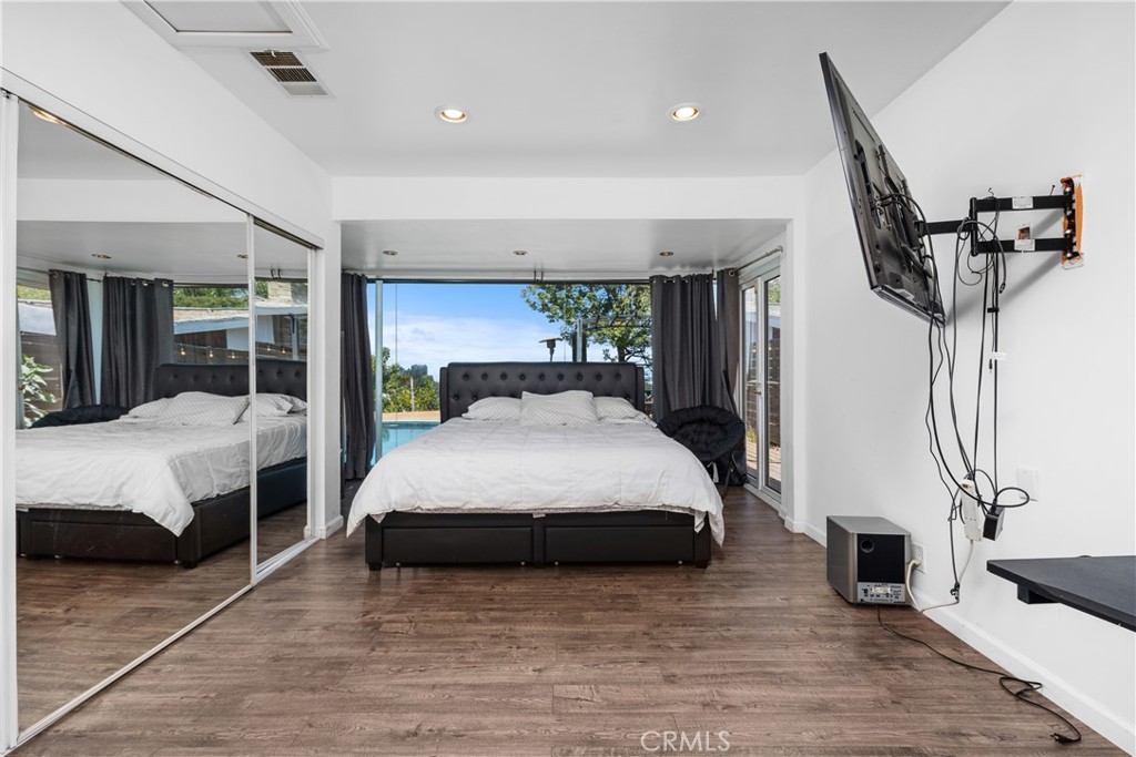 7241 Woodrow Wilson Drive Los Angeles, CA 90068 - Photo 16 of 43 a bedroom with a bed a mirror and desk