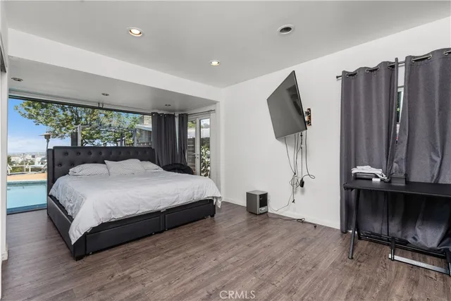 a bedroom with a bed and a flat tv screen on wall