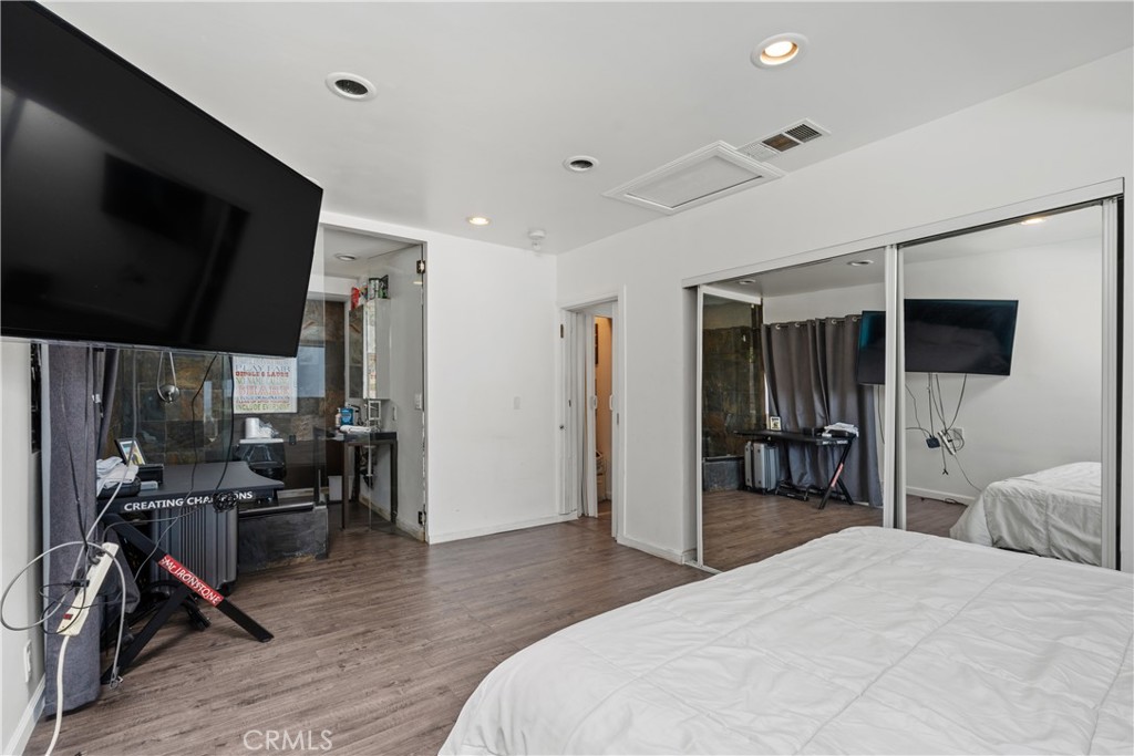 7241 Woodrow Wilson Drive Los Angeles, CA 90068 - Photo 18 of 43 a bedroom with a bed and a flat tv screen on wall