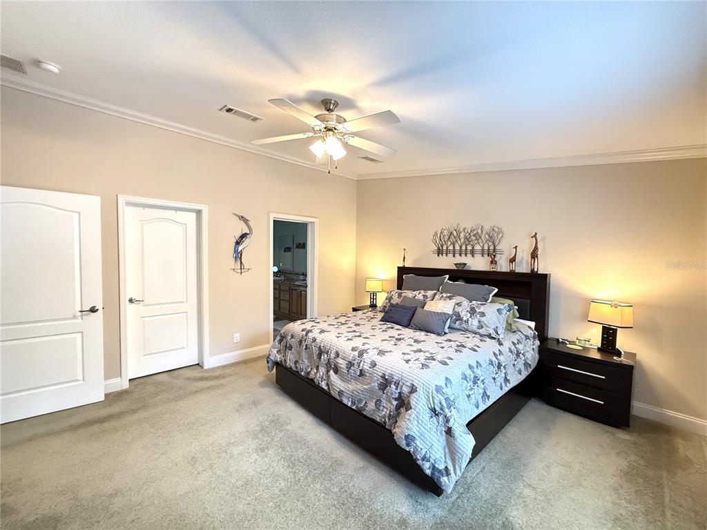8261 Northeast 118 Terrace Bronson, FL 32621 - Photo 14 of 43 a bedroom with a bed and a chandelier