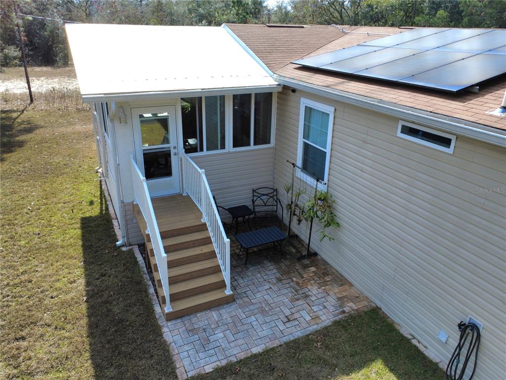 8261 Northeast 118 Terrace Bronson, FL 32621 - Photo 34 of 43 a view of a patio with table and chairs with wooden floor and fence