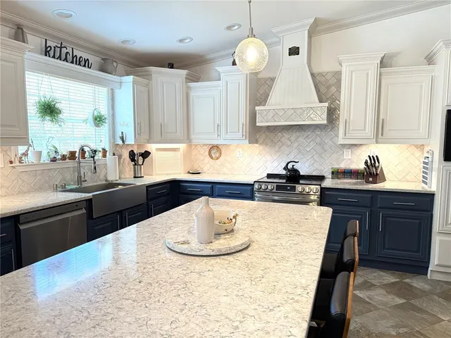 a kitchen with a stove a sink a refrigerator dining table and chairs