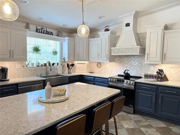 a kitchen with a sink a stove and wooden cabinets
