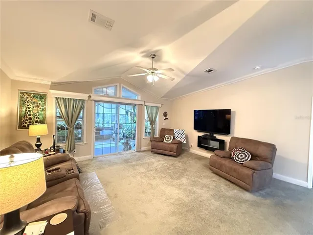 a bedroom with furniture a flat screen tv and a large window