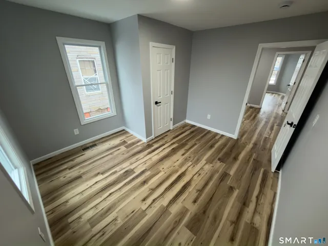 a view of a room with wooden floor and window
