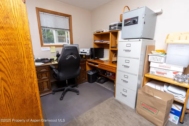 a bedroom with a bed and large windows