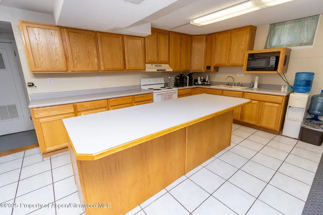 a kitchen with stainless steel appliances kitchen island granite countertop a sink counter space and cabinets