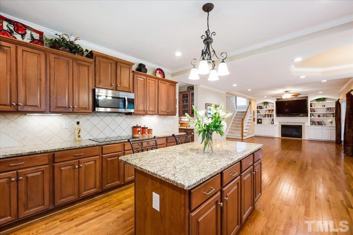 2624 Falls River Avenue Raleigh, NC 27614 - Photo 12 of 38 a kitchen with stainless steel appliances granite countertop a kitchen island a stove a sink dishwasher and a microwave with wooden floor