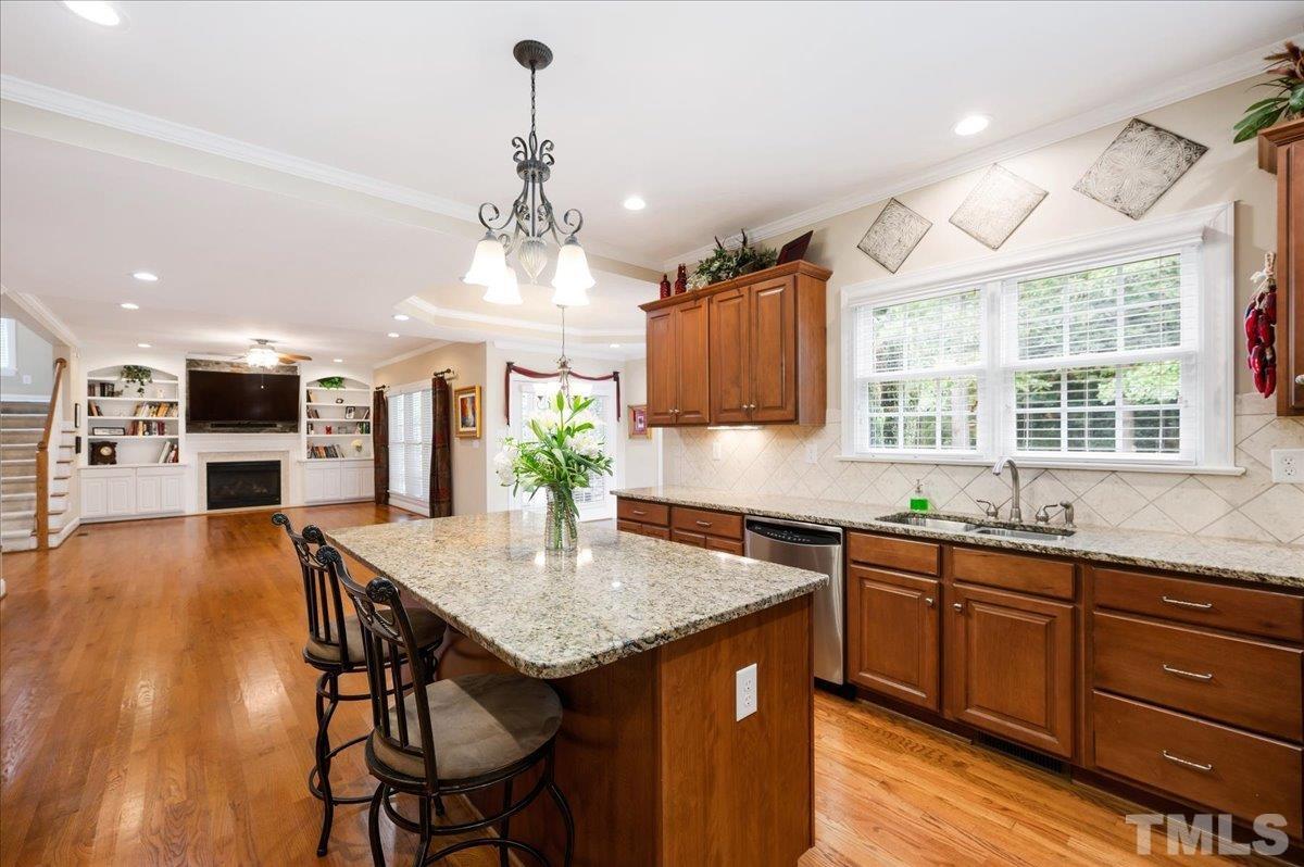 2624 Falls River Avenue Raleigh, NC 27614 - Photo 13 of 38 a open kitchen with stainless steel appliances granite countertop a kitchen island a stove a table and chairs in it