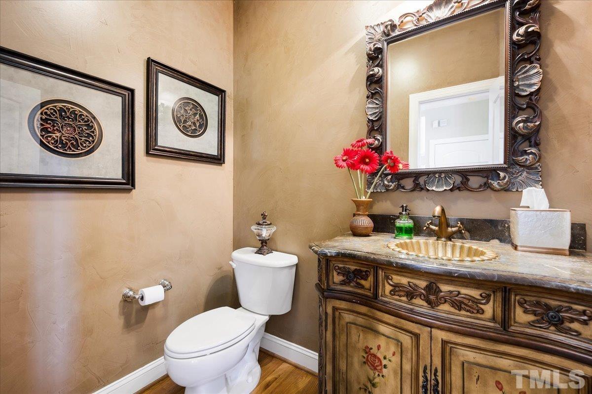 2624 Falls River Avenue Raleigh, NC 27614 - Photo 21 of 38 a bathroom with a toilet a sink and a mirror