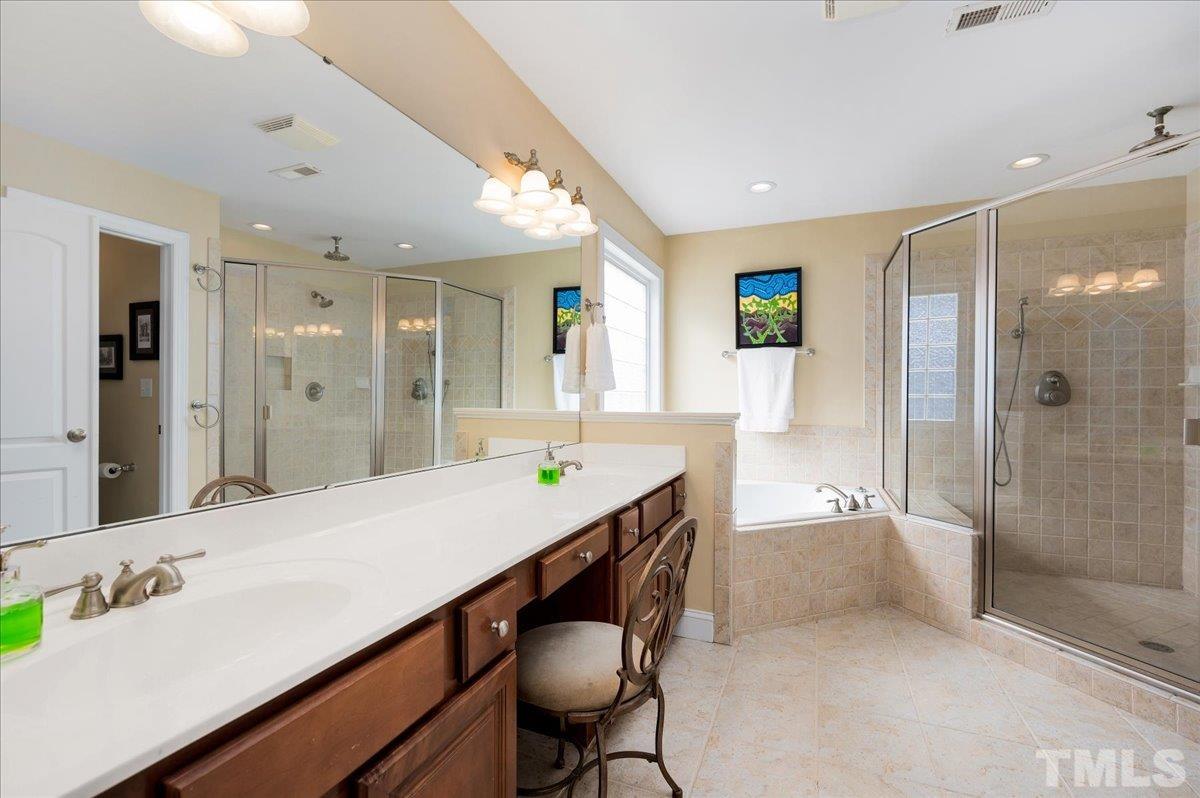 2624 Falls River Avenue Raleigh, NC 27614 - Photo 23 of 38 a spacious bathroom with a shower sink and mirror