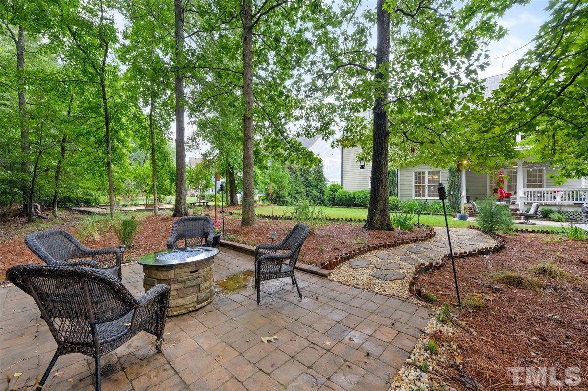 2624 Falls River Avenue Raleigh, NC 27614 - Photo 36 of 38 a view of a patio with table and chairs and potted plants and large trees