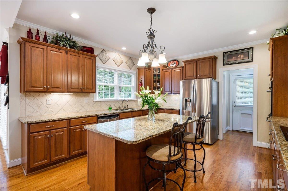 2624 Falls River Avenue Raleigh, NC 27614 - Photo 10 of 38 a kitchen that has a table chairs in it and wooden floors