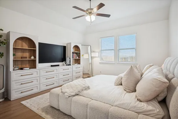 a bedroom with a bed flat screen tv and a window