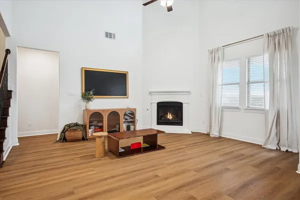 a living room with furniture a fireplace and a flat tv screen on dresser