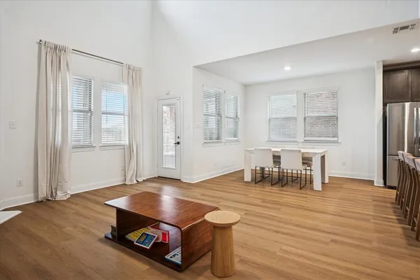 a living room with furniture pool table and wooden floor