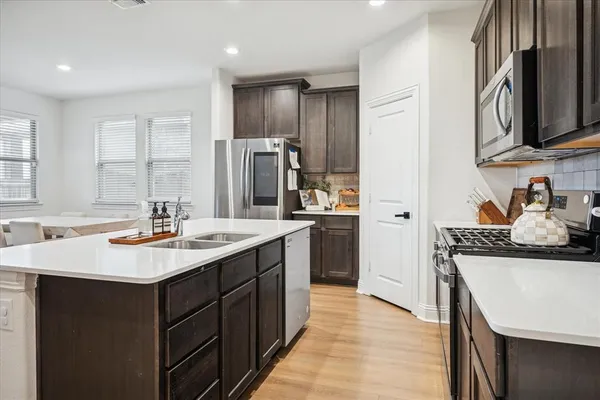 a kitchen with stainless steel appliances granite countertop a sink stove and refrigerator