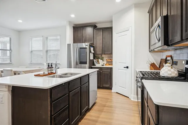 a kitchen with stainless steel appliances granite countertop a sink stove and refrigerator