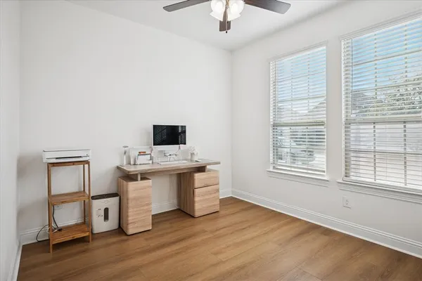 a view of a workspace with wooden floor and a window