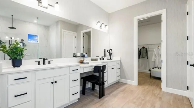 a spacious bathroom with a double vanity sink a mirror and a shower
