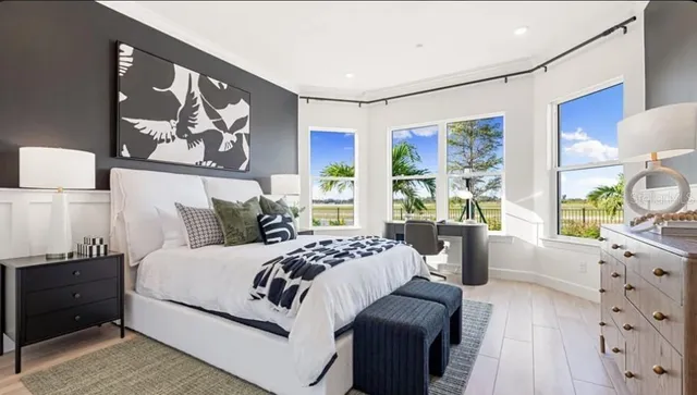 a bedroom with a large bed and a window with couch