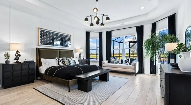 a bedroom with a large bed and a chandelier